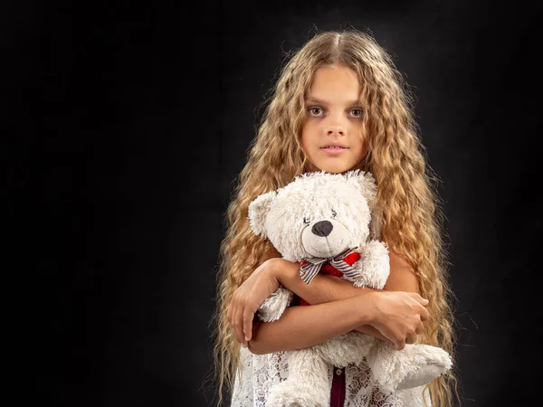 Портрет девочки-подростка, которая обнимает старого мягкого игрушечного медведя — стоковое фото