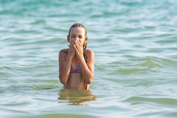The girl drowned in sea water and wipes her nose and face with her hands — Stock Photo, Image
