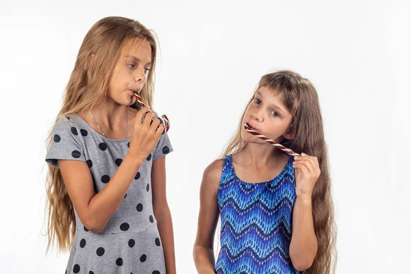 Duas meninas chupar doces de caramelo — Fotografia de Stock