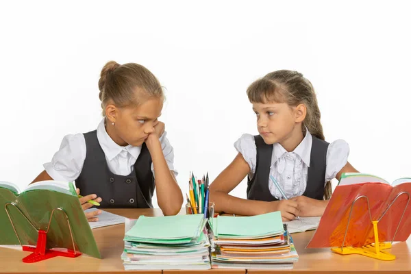 Two girls are sadly looking at each other, at a school desk — Stock Photo, Image