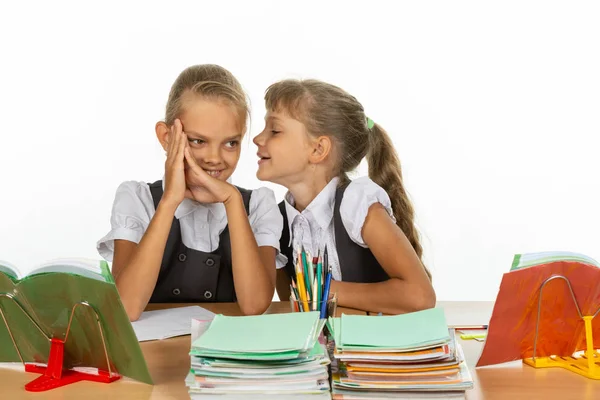 Девушка за школьным столом рассказывает что-то интересное на ухо — стоковое фото