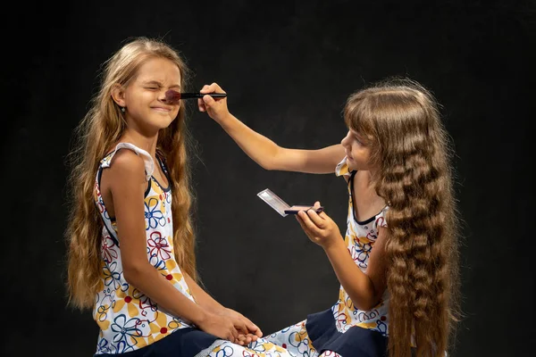 La fille ferma les yeux quand une autre fille poudra son nez avec un pinceau — Photo