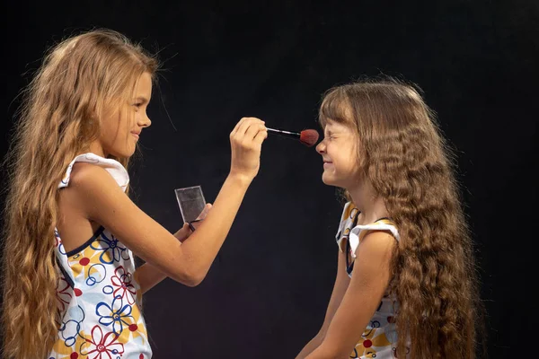 Mädchen pudert Nase zu ihrer Schwester, Schwester schielt vor Kitzeln — Stockfoto