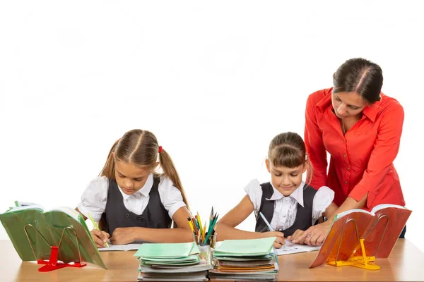 De leraar gaat rond de studenten, kijkt in de notebook, de studenten de taak op te lossen — Stockfoto