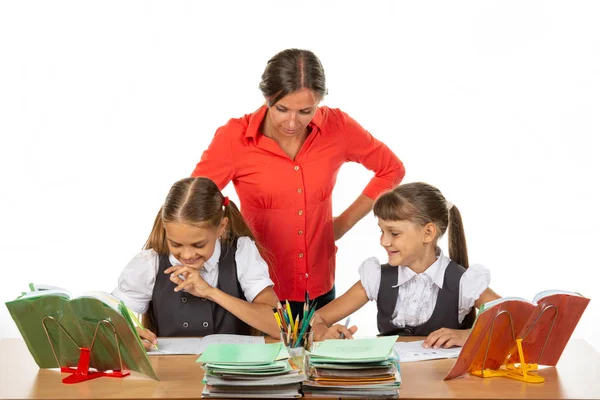 Teacher and student look in the notebook of another student, where something funny — Stock Photo, Image