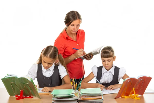 The teacher checks how students cope with the assignment and notes the progress in the diary — Stock Photo, Image