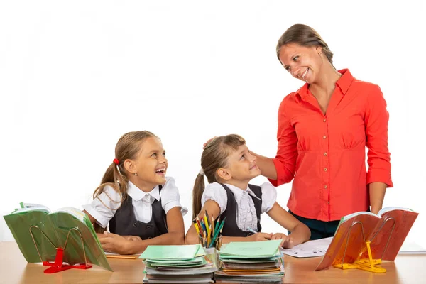 Amable maestro se comunica con los estudiantes sentados en un escritorio —  Fotos de Stock