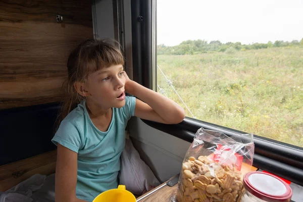 Девушка, сидящая на зарезервированном сиденье зевая машина смотрит в окно — стоковое фото