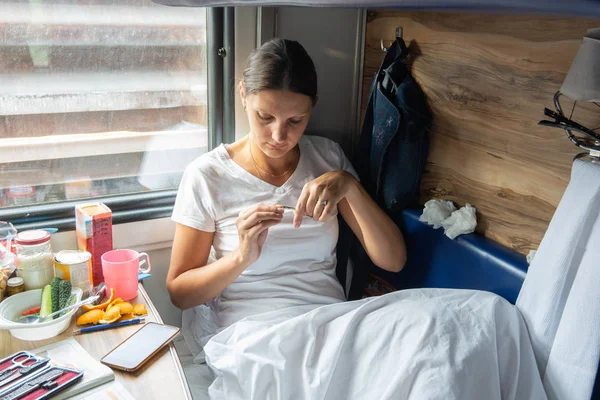 Девушка стрижет ногти в зарезервированном кресле поезда — стоковое фото