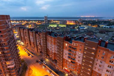 Volgograd, Rusya - 24 Ağustos 2019: Gün batımından sonra yapım aşamasındaki yeni yerleşim bölgesi ve Volga Nehri manzaralı Cityscape havadan görünümü