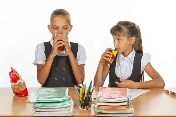Dwóch szkolnych przyjaciół pić sok przy stole w klasie szkolnej — Zdjęcie stockowe