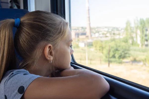 Teen ragazza guarda fuori dalla finestra in un treno elettrico — Foto Stock