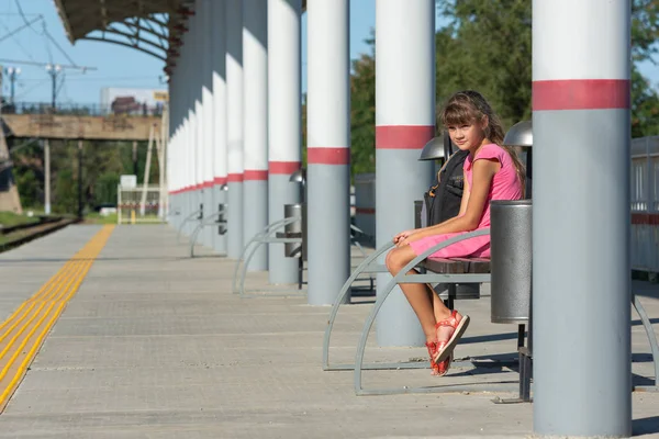 Восьмилетняя девочка сидит одна на пустой платформе вокзала — стоковое фото