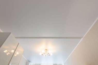 Ortasında beş lamba avizesi olan klasik beyaz mat esneme tavanı.