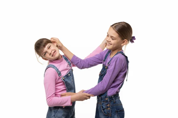 Het Oudste Meisje Sleept Jongste Aan Het Oor Geïsoleerd — Stockfoto