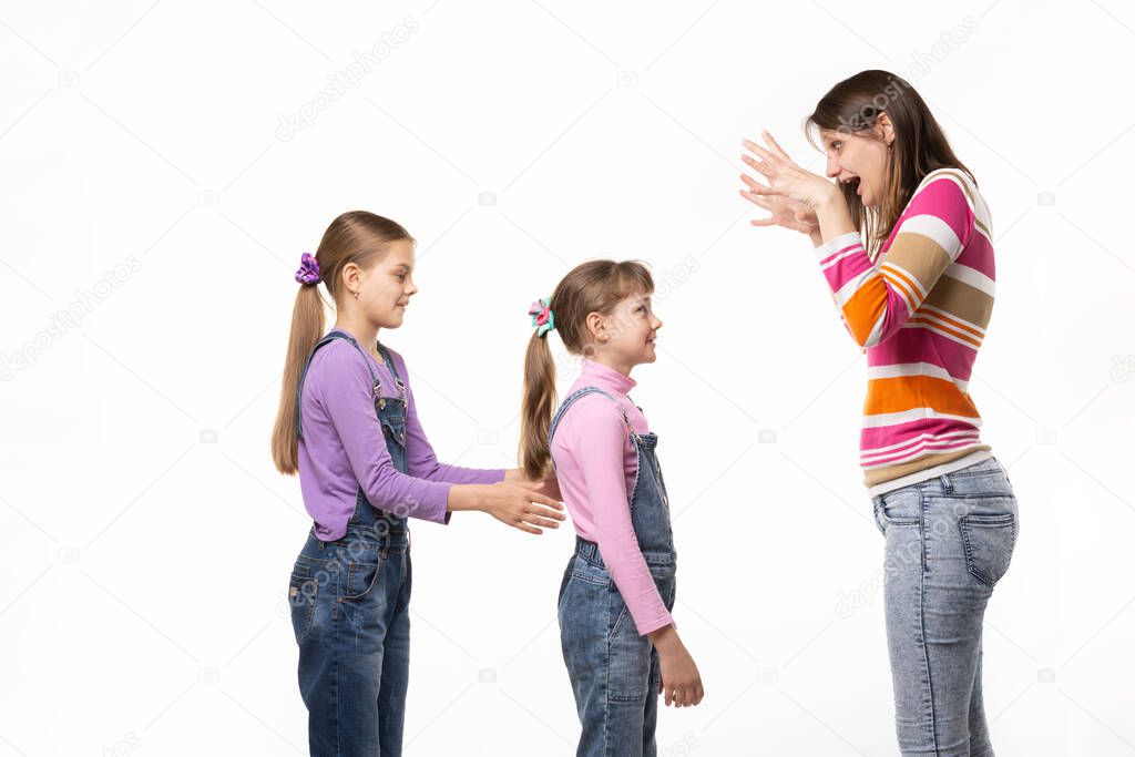 Mom scares her two daughters, isolated on white background