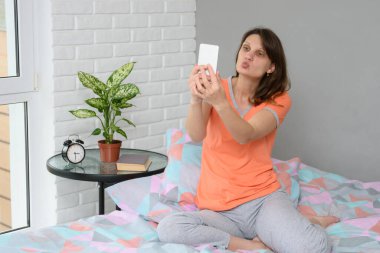 Kız video aracılığıyla iletişim kurarken öpücük gönderiyor.