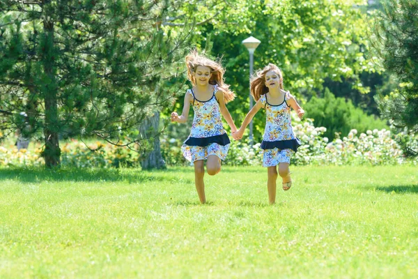 Две Младшие Сестры Бегают Зеленой Лужайке Парке — стоковое фото