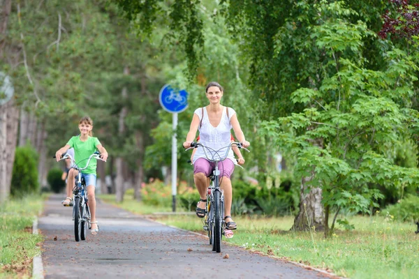 ママと娘は公園で自転車に乗る — ストック写真