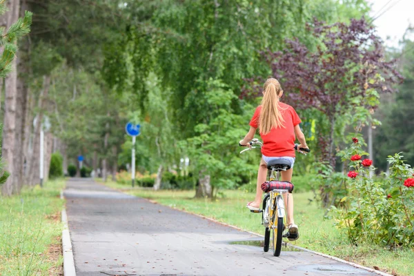 公園の自転車道で赤いTシャツの女の子 — ストック写真