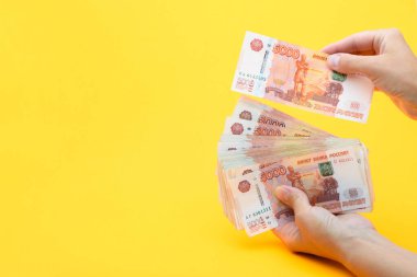 Eller beş binlik banknotlardaki miktarı sayar.
