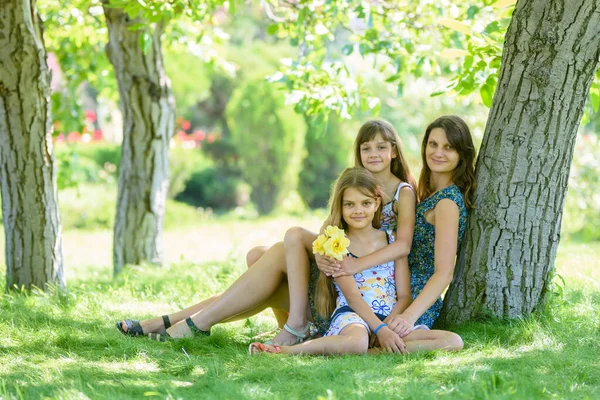 Mutter Mit Zwei Töchtern Sitzt Auf Grünem Gras Neben Baum — Stockfoto