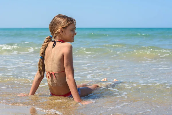 Uma Menina Dez Anos Senta Água Costa Mar — Fotografia de Stock