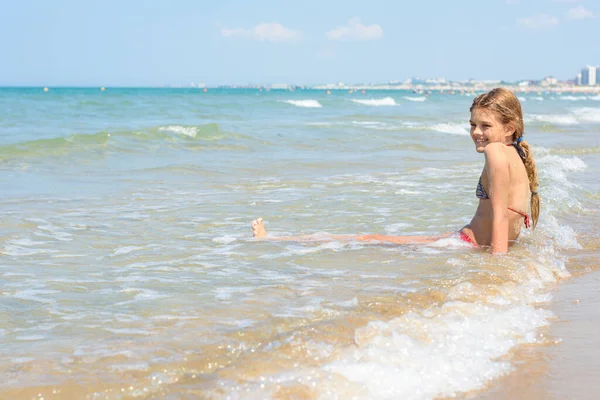 Una Ragazza Dieci Anni Siede Acqua Una Spiaggia Vuota — Foto Stock