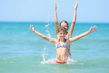 İki kız birbirini destekledi ve sevinçle ellerini kaldırdı..