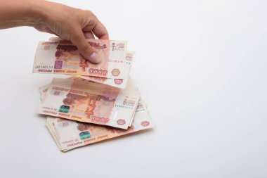 Beyaz arka planda 5000 rublelik banknotlar fırlatıyor.