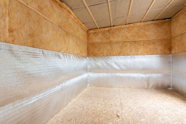 Bir evin inşaatı sırasında izolasyonun kombinasyonu, ısı yalıtımlı yansıtıcı köpüklü polietilen tabakası bir evi yalıtırken lavsan ile kaplanmış.