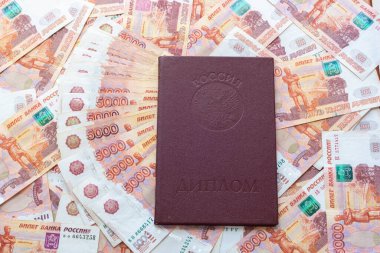 Beş bininci banknotun arka planında onur madalyası olan kırmızı bir diploma var.