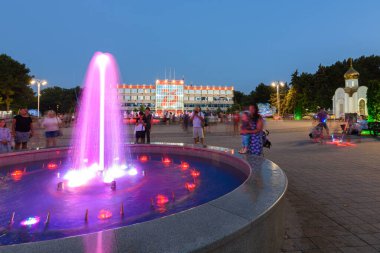 Anapa, Rusya - 17 Temmuz 2020: Üzerinde fıskiyeler ve küçük bir şapel bulunan Anapa tatil beldesi yönetiminin önündeki turist dolu meydanın görüntüsü