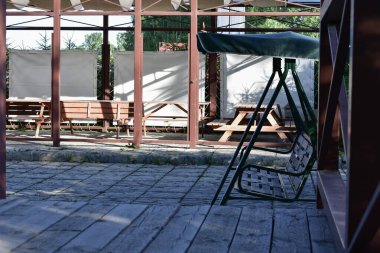 Bir kır evinin avlusunda sallanan bank