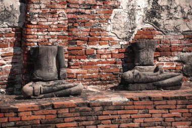 Ayutthaya Tayland 'daki tuğla duvarın yakınındaki taş heykellerin kalıntıları.