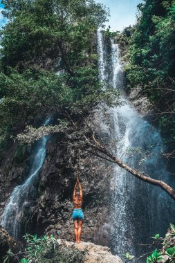 Young woman under a tree near a waterfall Jogjakarta Jawa Indonesia