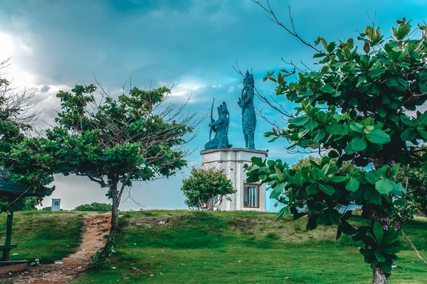 Arjuna Krishna statue on a green plain among the trees Bali Indonesia