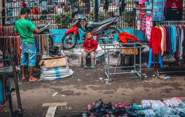 Bandung Jawa Endonezya pazarında motosikletin yanında bir çocuk.