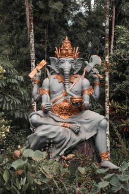 Ormanda balta ile Ganesha heykeli bali