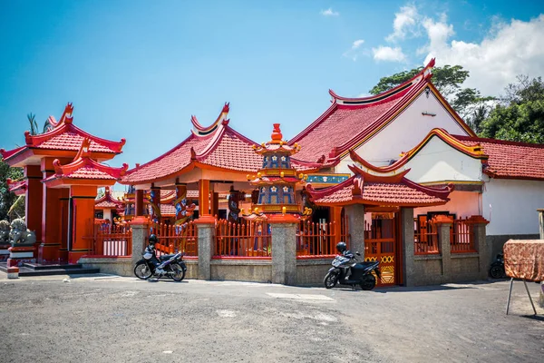 Chinese red temple with two motorcycles near the fence bali