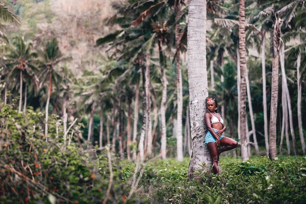 Beyaz Sütyenli Mavi Şortlu Afrikalı Kız Palmiye Ağacının Yanında Dikilip — Stok fotoğraf