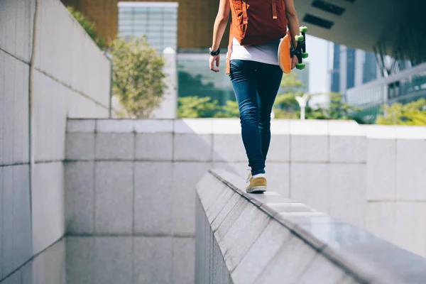 都市の都市建物壁のエッジの上を歩く若い女性 — ストック写真