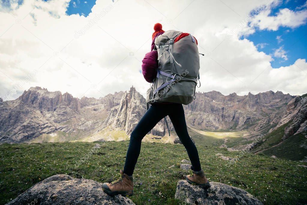 woman hiker with backpack hiking at high altitude mountains