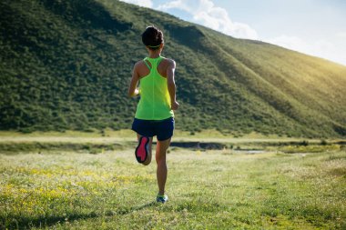 Yeşil çayır üzerinde çalışan genç kadın