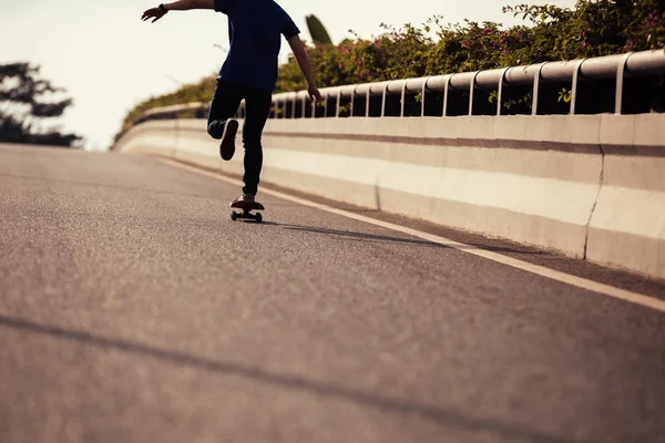 Cropped image of skateboarder skateboarding on city street