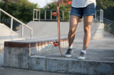 Genç kadının skatepark kaykay ile resim kırpılmış