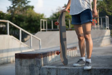 Genç kadının skatepark kaykay ile resim kırpılmış