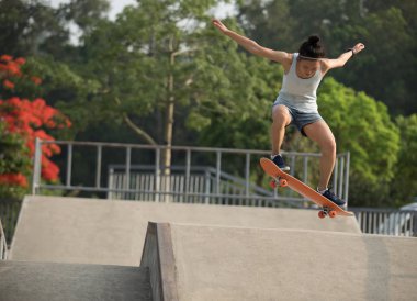Genç kadın kaykaycı skatepark rampa üzerinde kaykay