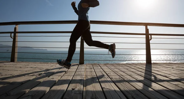 Sahil sahil üzerinde gündoğumu sırasında çalışan sportif kadın runner 