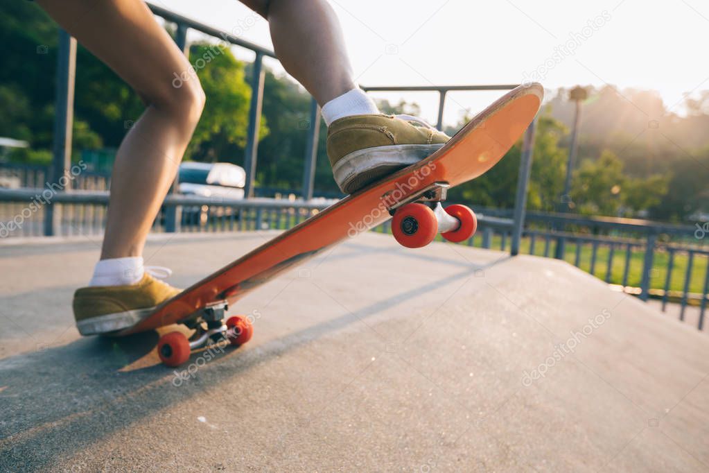 Cropped image of skateboarder skateboarding on skatepark ramp